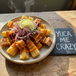 Yuca Me Crazy – Fried Yuca with Pork Chicharrón Perfectly fried yuca topped with seasoned pork chicharrón, fresh criolla salsa, and creamy rocoto mayo. A crunchy, savory Salvadoran favorite bursting with texture and bold flavor.